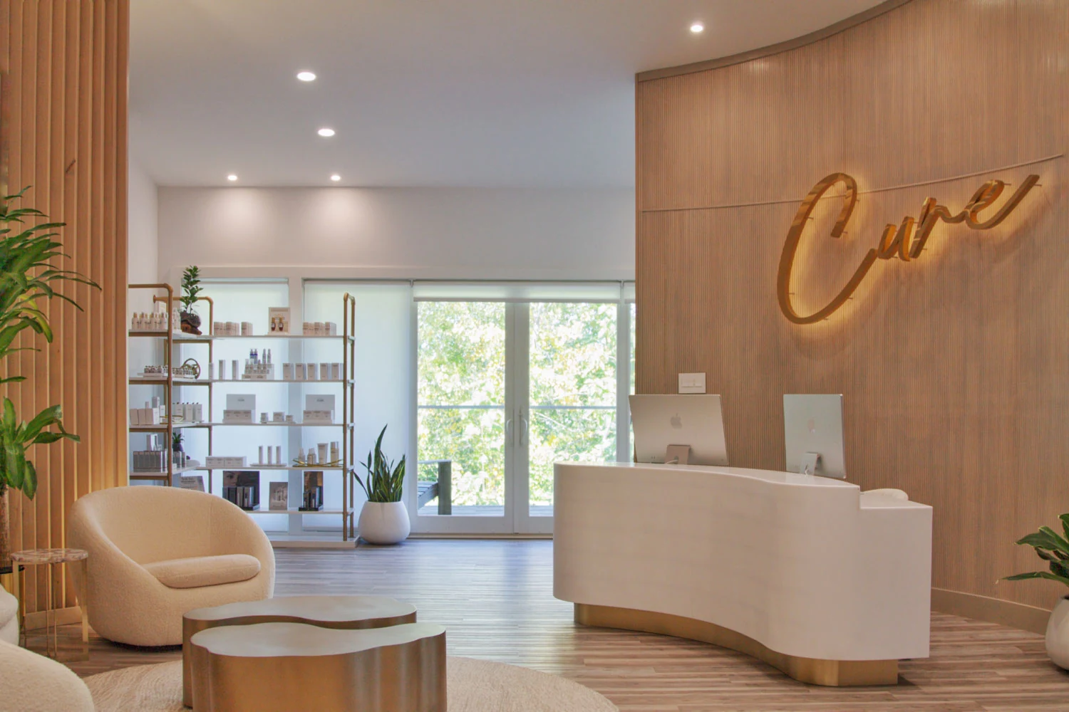 A bright medspa reception with a curved desk and warm wood finishes